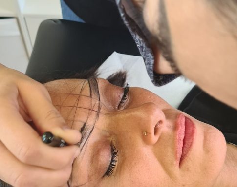 Femme allongée, se faisant dessiner des sourcils avec un marqueur.