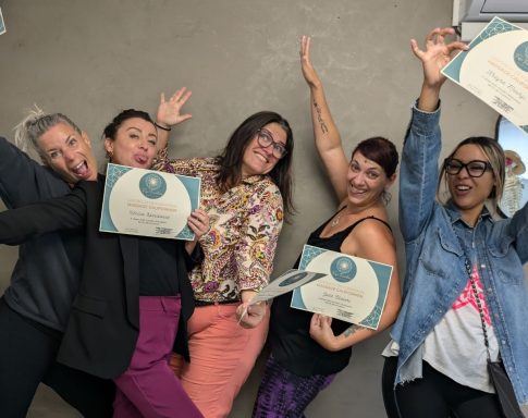 Cinq femmes posant joyeusement, tenant des certificats, avec des expressions enthousiastes.